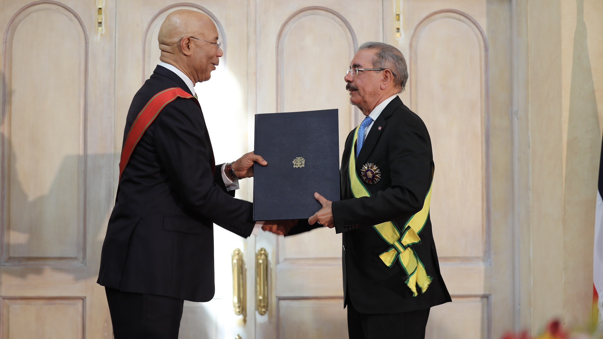 Medina y Holness se intercambian condecoraciones