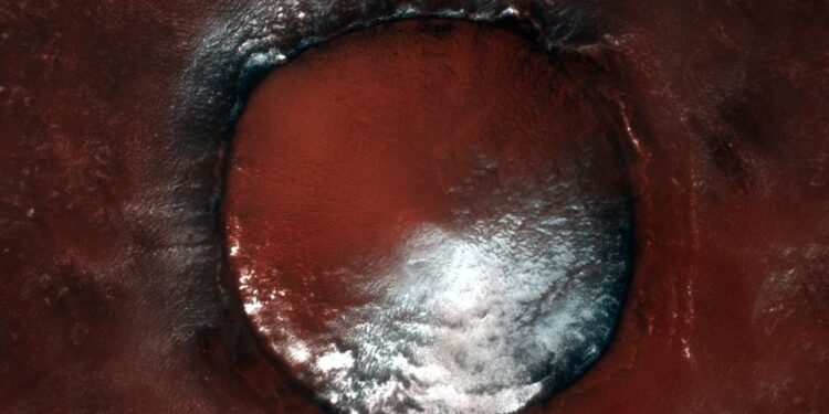 El hielo resiste en la umbría de un rojizo cráter de Marte